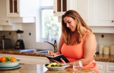 Tučná žena si zapisuje ako bude prebiehať bodová diéta