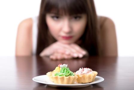 Žena drží redukčnú diétu a rozmýšľa, či zje koláč