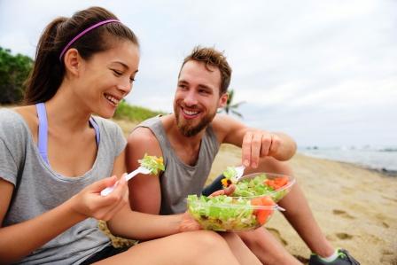 Ako zvládnuť diétu v lete - zena a muz jedia pri mori.jpg