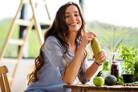 Krásna šťastná žena sedí s nápojmi a zdravé zelené jedlo a drží Dash dietu