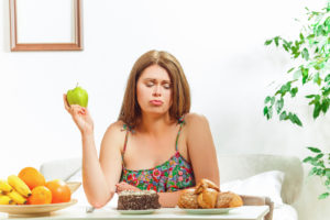 chudnutie - pokusenie - zena sa rozhoduje medzi ovocim a sladkym